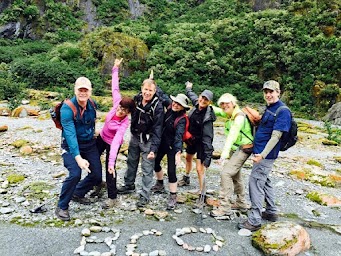 group with arms out pointing to BCO spelled in rocks.